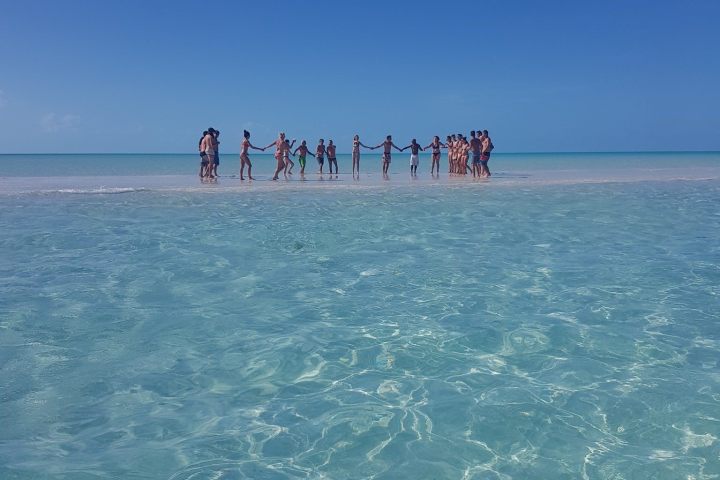a group of people standing next to a body of water